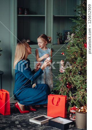 Little girl and her mom on Christmas morning at 120652909