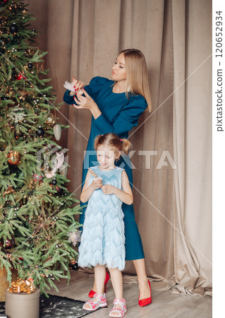 Little girl and her mom on Christmas morning at 120652934