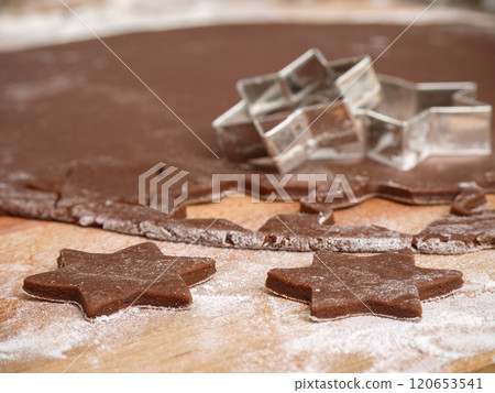 Star-Shaped Cookie Cutters on Brown Dough with Flour 120653541