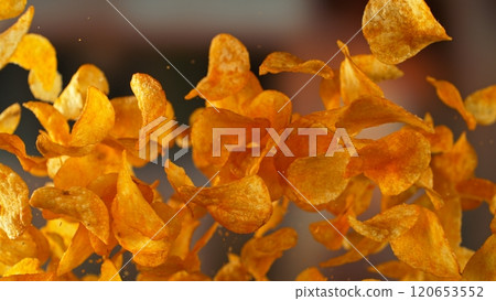 Freeze motion of flying fried potatoes chips on gradient yellow background 120653552
