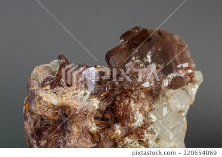 Macro minerals Axinite stone on a gray background 120654069