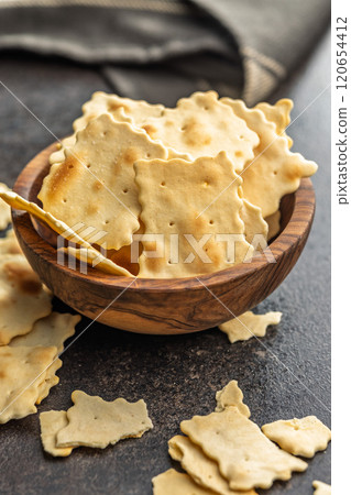A crispy salted crackers in bowl on black table. 120654412