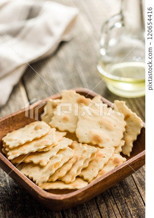 A crispy salted crackers in bowl on wooden table. A crispy salted crackers in bowl on wooden table. 120654416