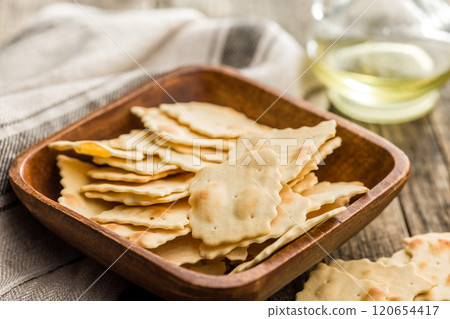 A crispy salted crackers in bowl on wooden table. 120654417