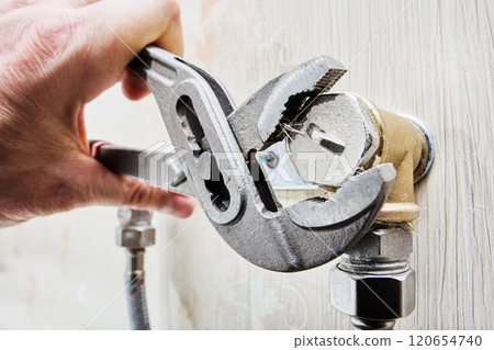 Installing plug on elbow fitting of mixer tap mounting bracket using an adjustable wrench. Installing plug on elbow fitting of mixer tap mounting bracket using an adjustable wrench. 120654740
