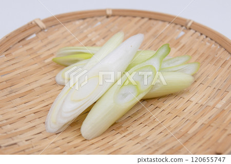 Diagonally cut white onions arranged in a colander 120655747