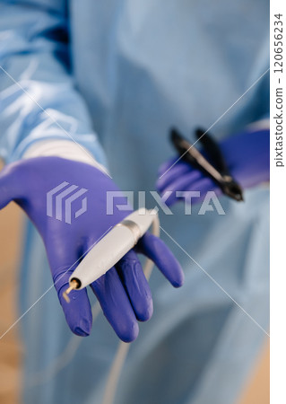 Dental tools held by a professional in sterile gloves, showcasing modern dentistry equipment Dental tools held by a professional in sterile gloves, showcasing modern dentistry equipment 120656234