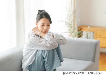 一名30多歲的女性坐在沙發上 120656373