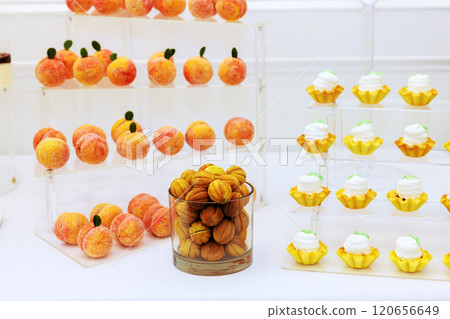 Assortment of desserts is presented in featuring fruit shaped confections, creamy treats sweets, perfect for celebration event 120656649