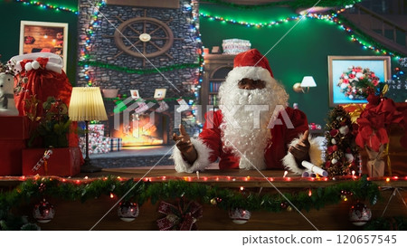 POV of african american santa waving and chatting with people on video call, communicating from his North Pole workshop. Saint Nick in festive costume spreading the holiday cheer. Camera B. POV of african american santa waving and chatting with people on video call, communicating from his North Pole workshop. Saint Nick in festive costume spreading the holiday cheer. Camera B. 120657545