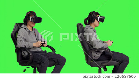 Asian person gaming with vr headset against greenscreen backdrop in studio, playing video games with controller. Young guy having fun with rpg competition, virtual reality leisure. 120657600