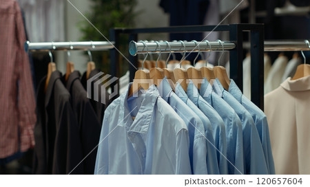 Refined fashion boutique merchandise displayed in the store with clothing on racks, showcasing a trendy chic selection of shirts and jackets that offer timeless style. Empty luxury showroom. Refined fashion boutique merchandise displayed in the store with clothing on racks, showcasing a trendy chic selection of shirts and jackets that offer timeless style. Empty luxury showroom. 120657604