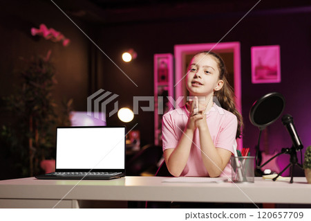 Talented young entertainer doing livestream, presenting mockup laptop to fans. Upbeat youngster does live broadcast in studio, showing online viewers isolated screen notebook 120657709