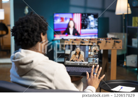 BIPOC man and coworkers in videoconference crosschecking analytics statistical data sets from apartment office. Businessman at home optimizing key performance indicators with colleagues in videocall BIPOC man and coworkers in videoconference crosschecking analytics statistical data sets from apartment office. Businessman at home optimizing key performance indicators with colleagues in videocall 120657829