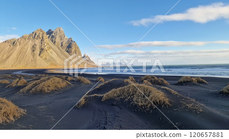 Black sand beach in amazing environment, lovely vestrahorn mountains and ocean shore in Iceland. Stokksnes beach providing wintry icelandic landscape of arctic coastline, freezing cold. Black sand beach in amazing environment, lovely vestrahorn mountains and ocean shore in Iceland. Stokksnes beach providing wintry icelandic landscape of arctic coastline, freezing cold. 120657881
