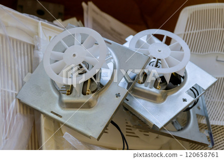 Ventilation fans are disassembled workbench in various components tools surround fans, indicating repair maintenance activities. Ventilation fans are disassembled workbench in various components tools surround fans, indicating repair maintenance activities. 120658761