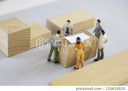 Miniature people discussing around a table 120658828