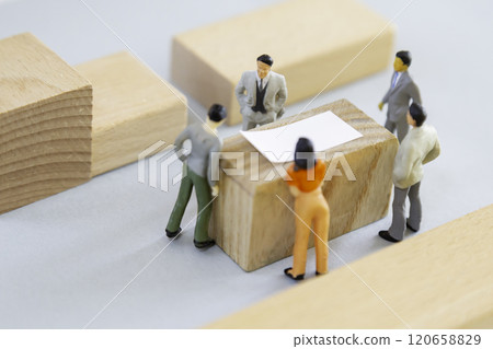 Miniature people discussing around a table 120658829