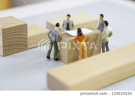 Miniature people discussing around a table Miniature people discussing around a table 120658830