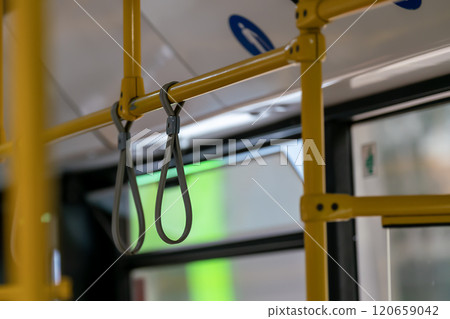 Flexible gray handles on yellow bus handrail. Flexible gray handles on yellow bus handrail. 120659042