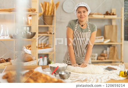 Woman works in bakery as baker, kneads dough, works with flour. Woman works in bakery as baker, kneads dough, works with flour. 120659214