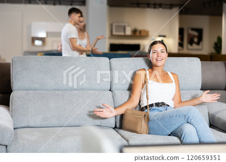 Young woman chooses sofa in store Young woman chooses sofa in store 120659351