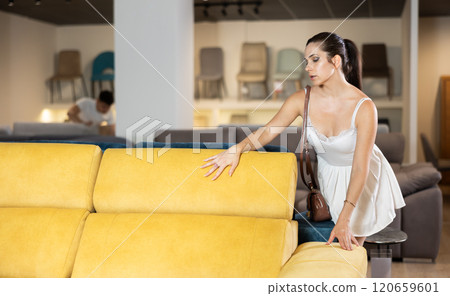 Young woman choosing convenient sofa in furniture shop 120659601