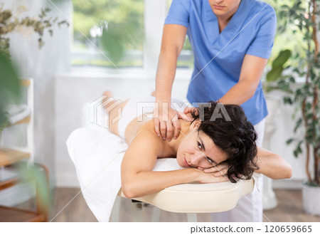 Portrait of young female which is lying on massage table in spa 120659665