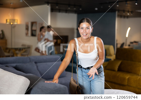 Young girl choosing convenient sofa in furniture shop Young girl choosing convenient sofa in furniture shop 120659744