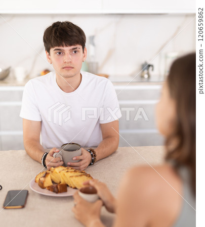 Young couple drinking tea and talking in kitchen 120659862