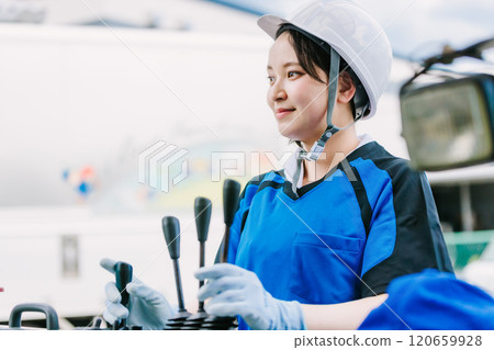 A woman in a helmet driving a forklift A woman in a helmet driving a forklift 120659928