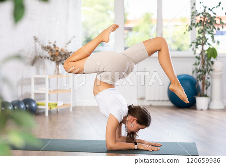 Experienced girl fitness club teacher performs scorpio asana, vrishchikasana Experienced girl fitness club teacher performs scorpio asana, vrishchikasana 120659986