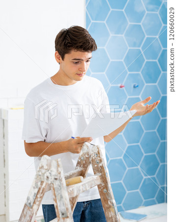 Confused young designer determining scope of work in apartment during refurbishment 120660029