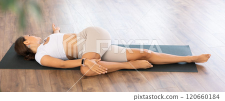 Experienced girl fitness club teacher performs supta ardha matsyendrasana Experienced girl fitness club teacher performs supta ardha matsyendrasana 120660184
