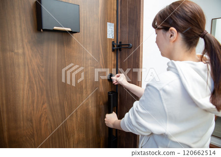 Back view of a Japanese woman opening the front door Back view of a Japanese woman opening the front door 120662514