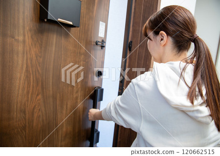 Back view of a Japanese woman opening the front door Back view of a Japanese woman opening the front door 120662515