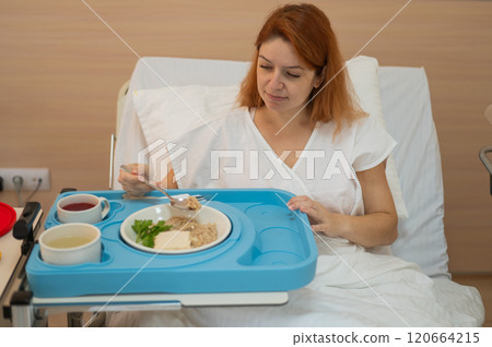 Caucasian woman eating on hospital bed. Caucasian woman eating on hospital bed. 120664215