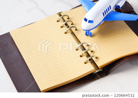 Image of an airplane and a planner planning your next long vacation trip 120664532