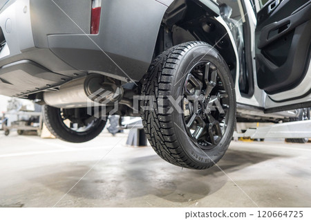 Car on a lift during tire change. Car on a lift during tire change. 120664725