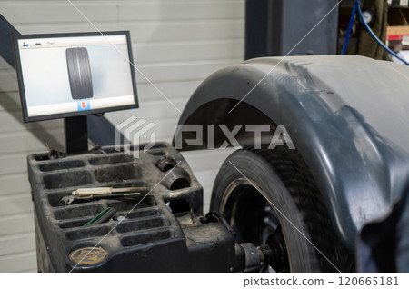 Wheel being balanced in a car workshop.  120665181
