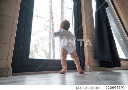 Baby boy standing by the patio window. Baby boy standing by the patio window. 120665191