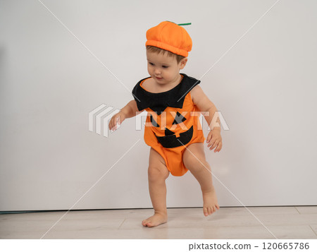 Cute Caucasian boy in pumpkin costume for Halloween.  120665786