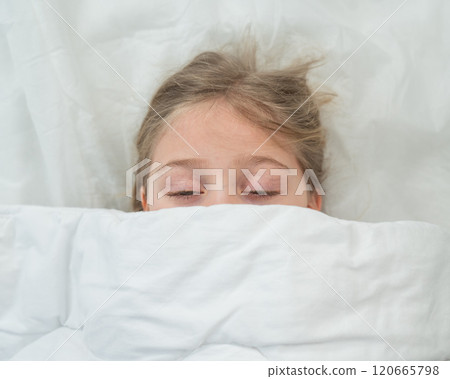 Top view of a little girl hiding under a blanket.  120665798