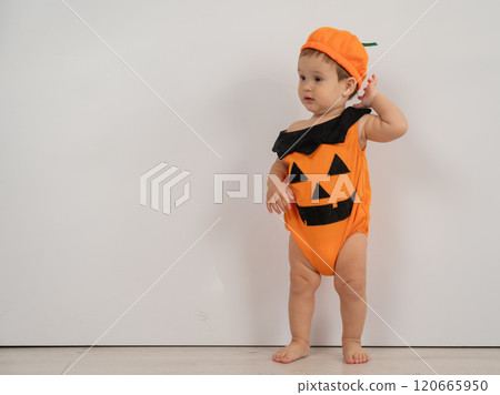 Cute Caucasian boy in pumpkin costume for Halloween.  120665950
