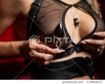 Woman holding steel anal plug against chest.  120666637