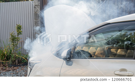 Smoke is coming from under the hood of the car.  120666701