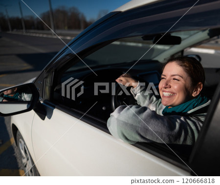 Happy Caucasian woman sitting behind the wheel looking out the window and smiling. Happy Caucasian woman sitting behind the wheel looking out the window and smiling. 120666818