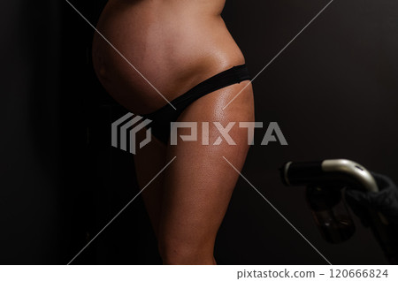 Faceless pregnant woman getting an instant tan. The master applies bronzer with a spray. 120666824