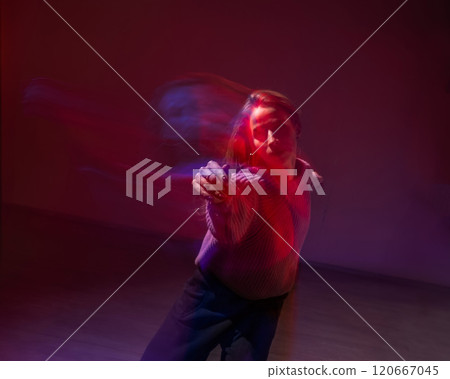 A young woman dances contemporary dances in blue and red light. Long exposure photo. A young woman dances contemporary dances in blue and red light. Long exposure photo. 120667045