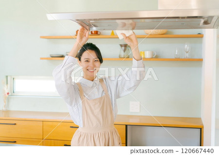 Woman cleaning the ventilation fan in the kitchen 120667440